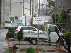駐車車両や庭木の横には「ここは徳島市の管理地です」の立て看板、問われる「不法占用」、市民病院近接地…